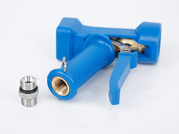 A lying water down gun with an NPT male thread placed next to it.